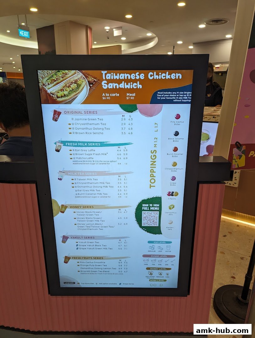 A digital menu board displaying various tea and sandwich options with prices.