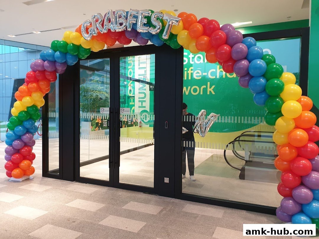 A rainbow balloon arch with 'GRABFEST' balloons over a shop entrance.