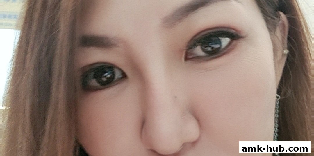 Close-up of a woman's eyes and nose, with makeup and long brown hair.