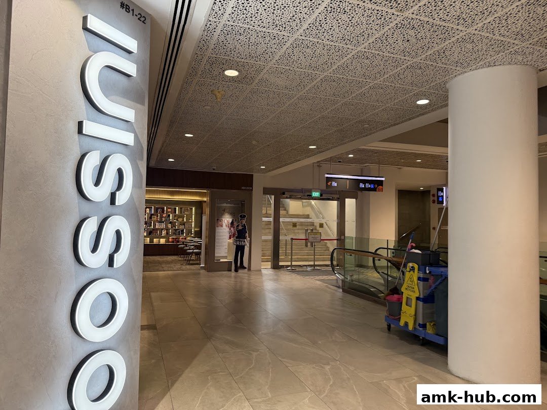 A mall corridor with a prominent "Luiss" sign and an escalator leading to shops.