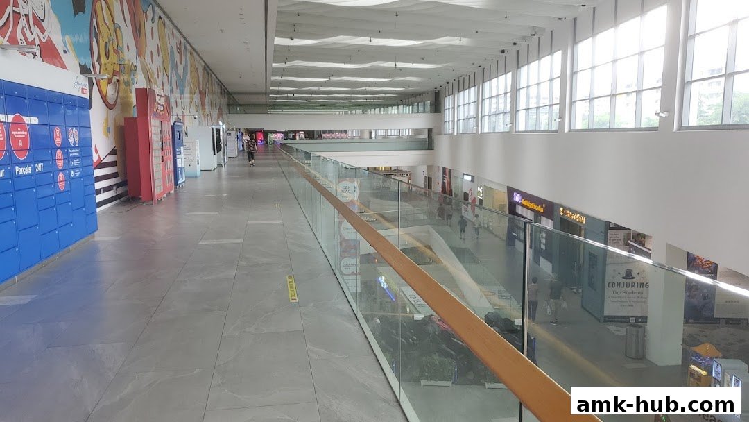 A wide shot of a modern shopping mall interior with shops and a long walkway.