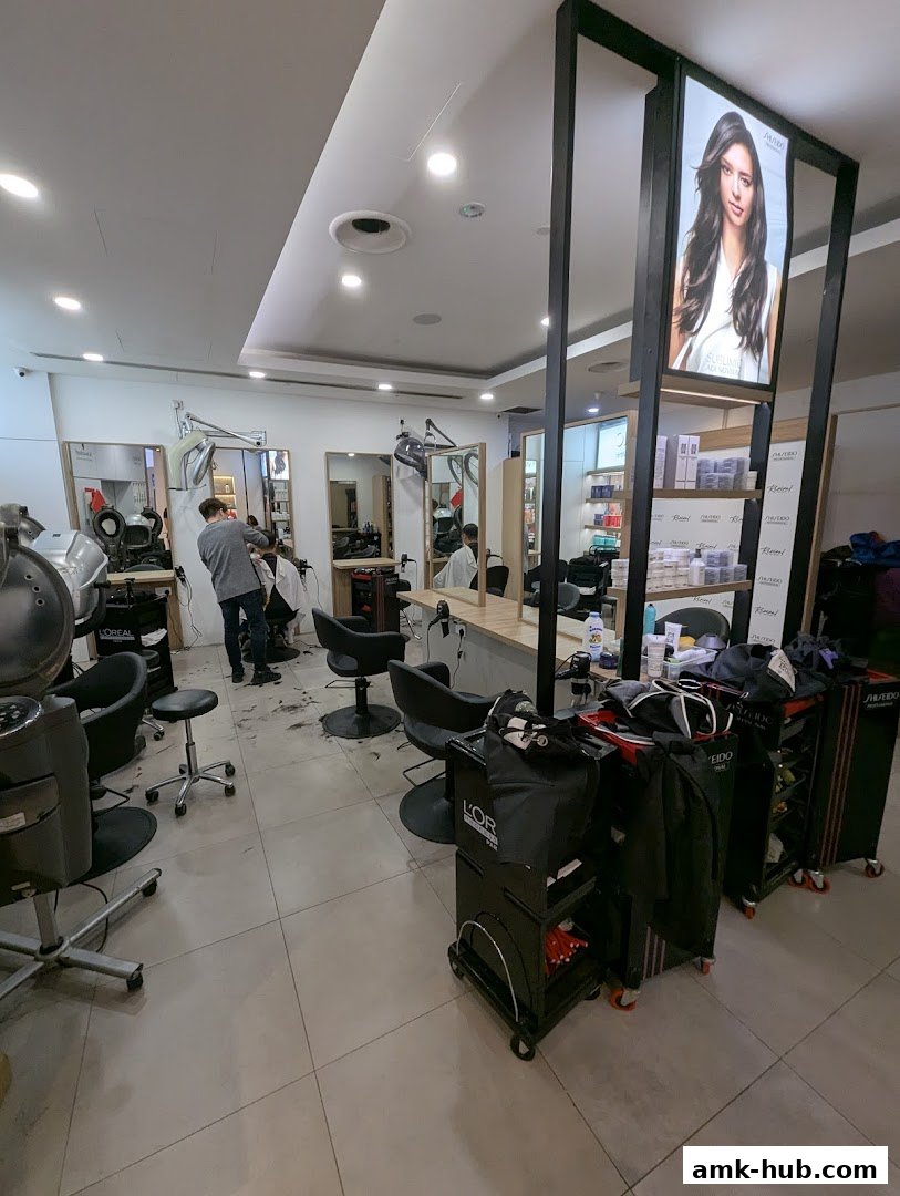 Interior of a modern hair salon with stylists working and product displays.