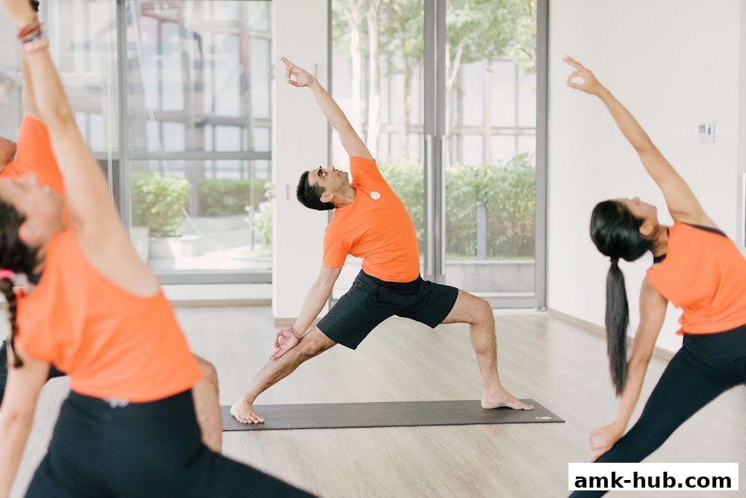 People practicing yoga in a bright studio with large windows.