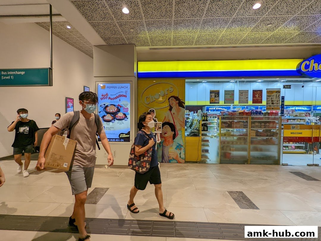People walk past a Cheers convenience store with a Pepper Lunch advertisement.