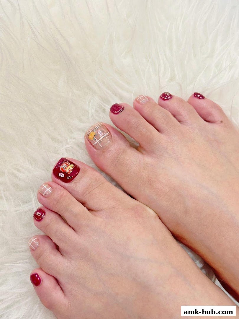 Close-up of feet with beautifully designed toenails featuring red, gold, and plaid patterns.