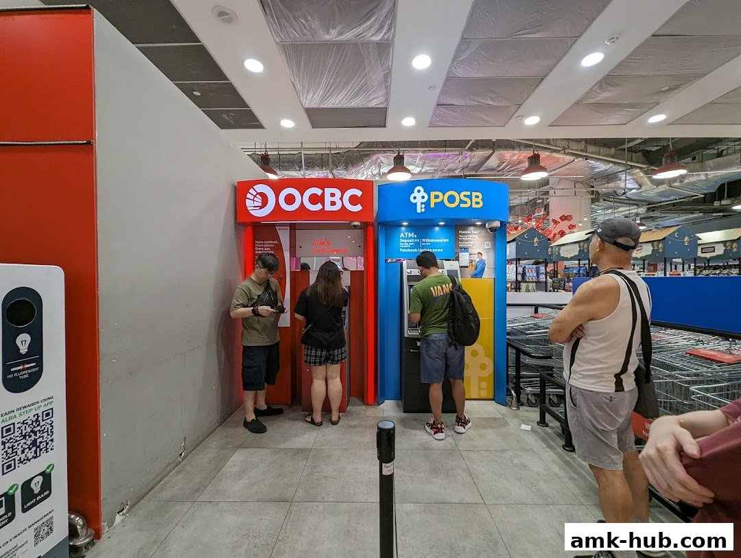 People using OCBC and POSB ATMs inside a Fairprice Xtra supermarket.
