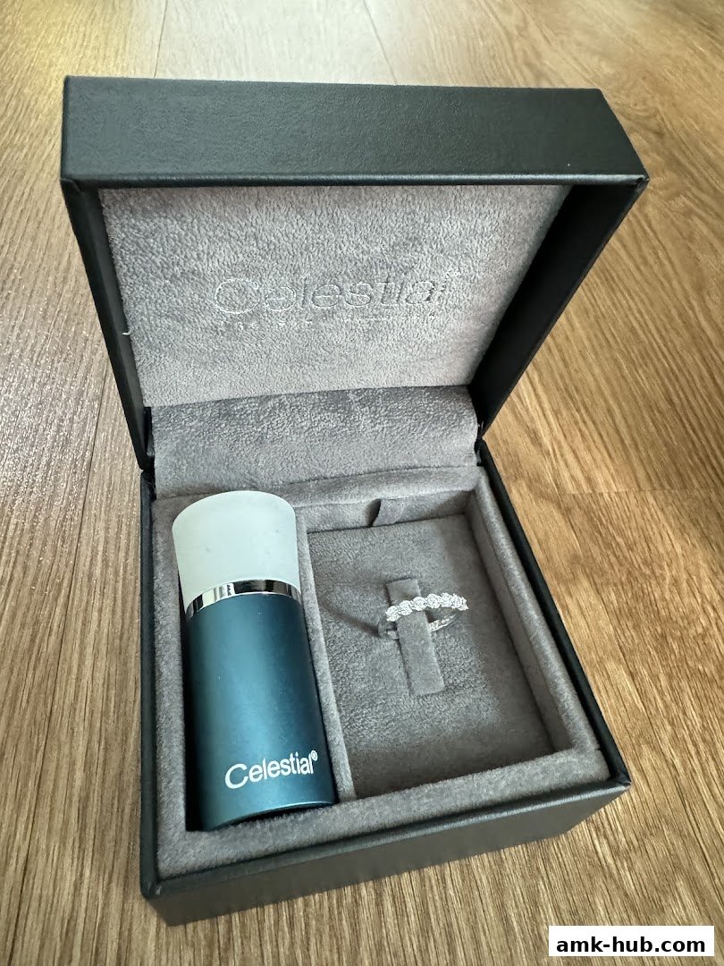 A jewelry box containing a diamond ring and a blue cylindrical item with the Celestial logo.