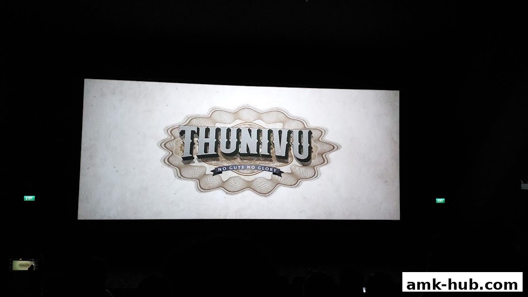 A movie title card for 'Thunivu' with the tagline 'No Guts No Glory' displayed on a screen.