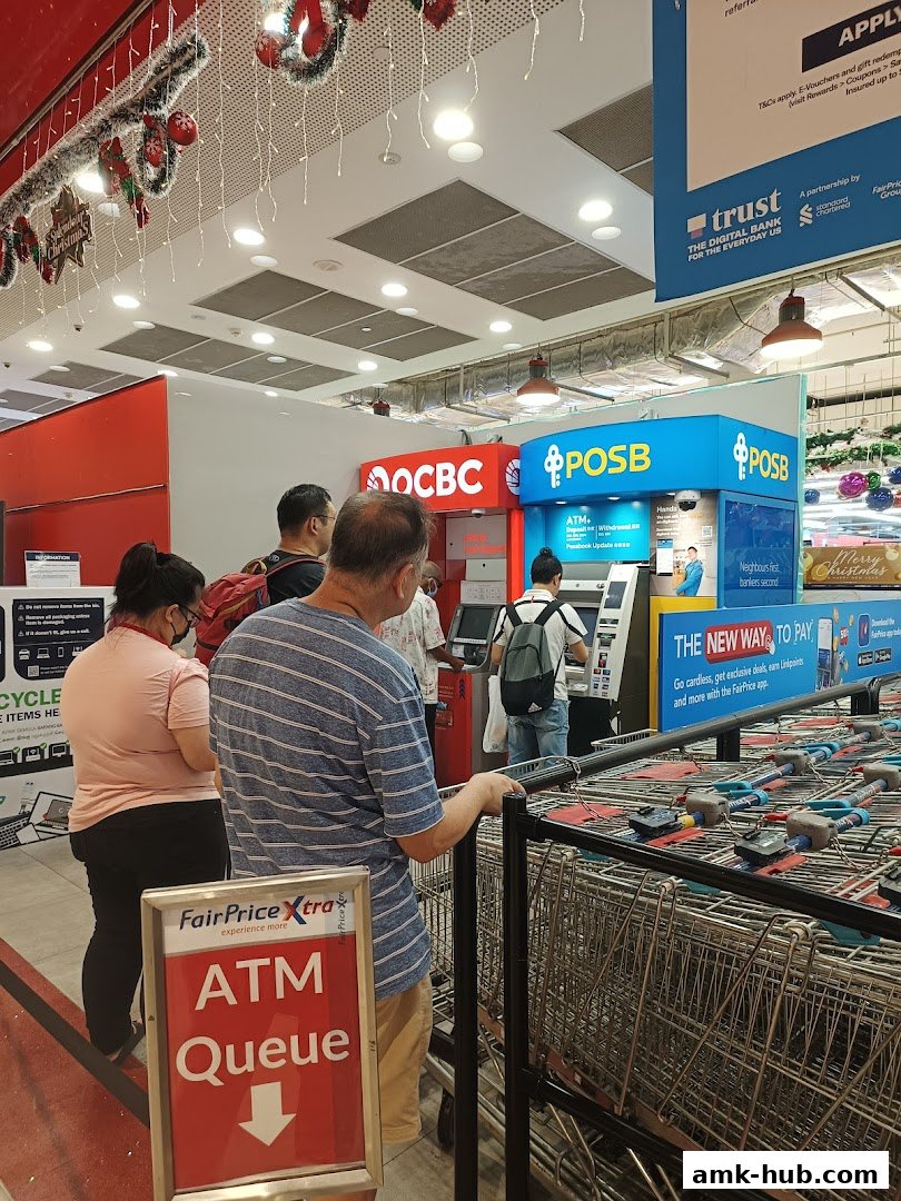 People queue at POSB and OCBC ATMs inside a store decorated for Christmas.