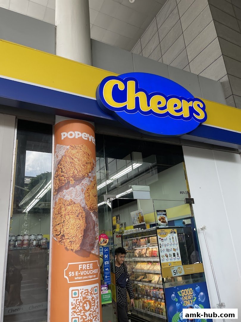 The exterior of a Cheers convenience store with a Popeyes advertisement and a person standing near the entrance.