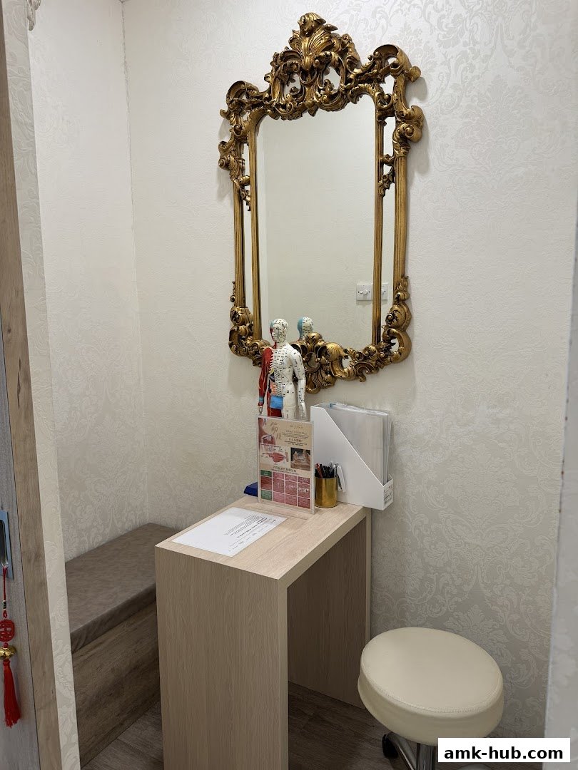 A reception desk with anatomical models and a decorative mirror in a spa.