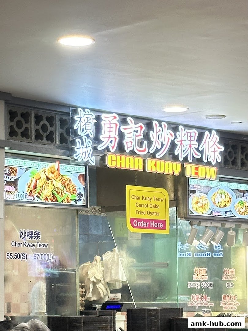 A food stall sign for Char Kuay Teow with pictures of dishes and prices.