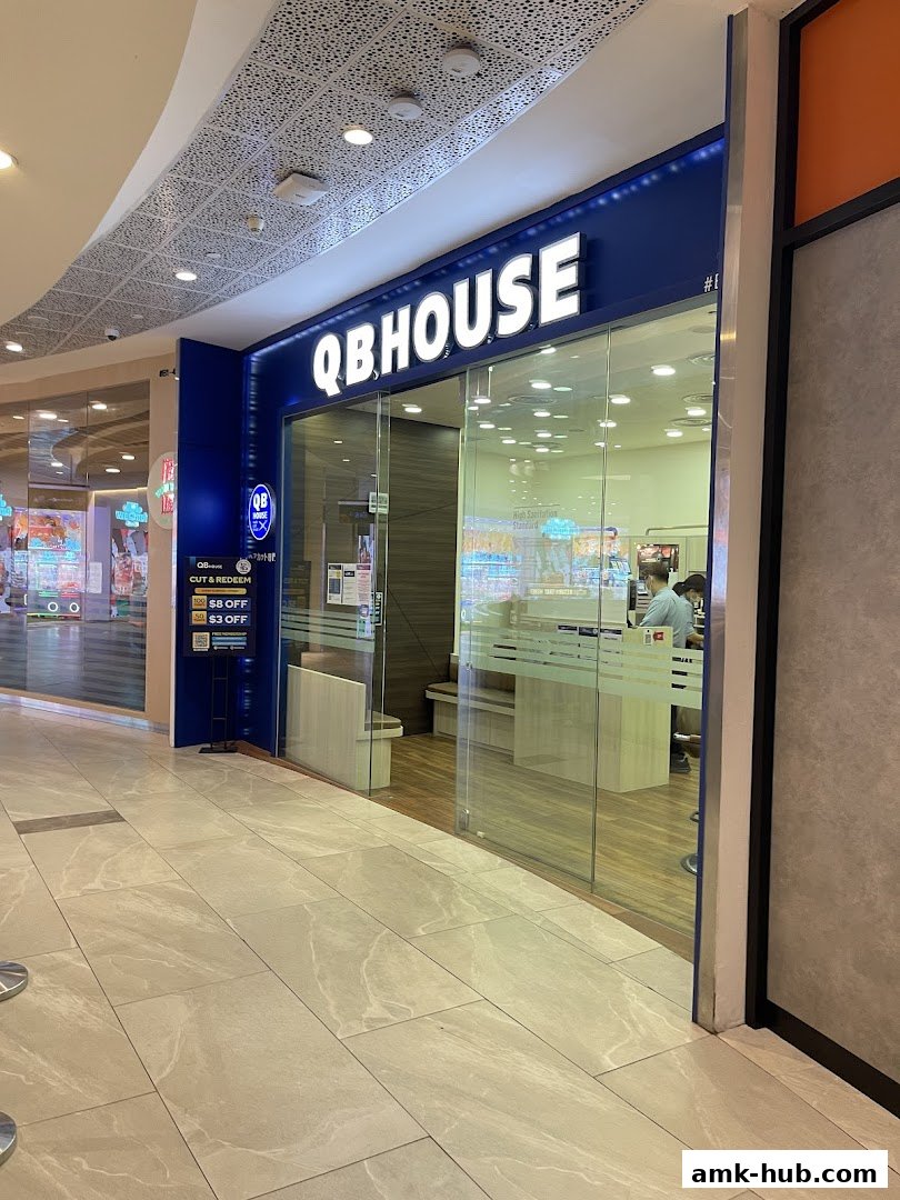 The exterior of a QB HOUSE hair salon with a prominent sign and glass entrance.