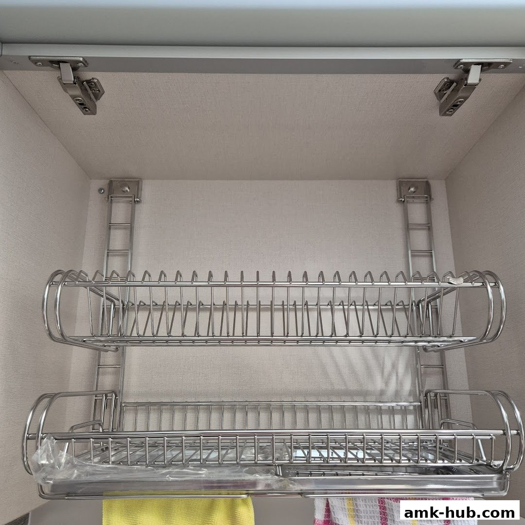 A two-tiered stainless steel dish rack mounted inside a cabinet.