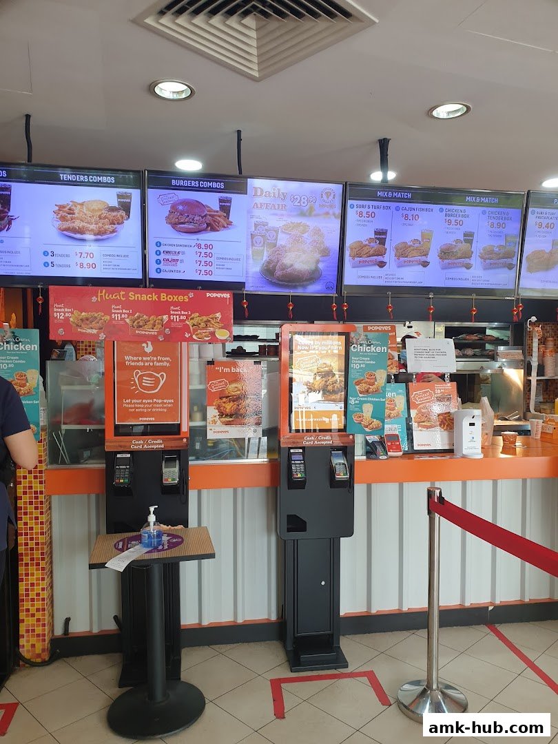 Popeyes restaurant interior with digital menus displaying food combos and snack boxes.