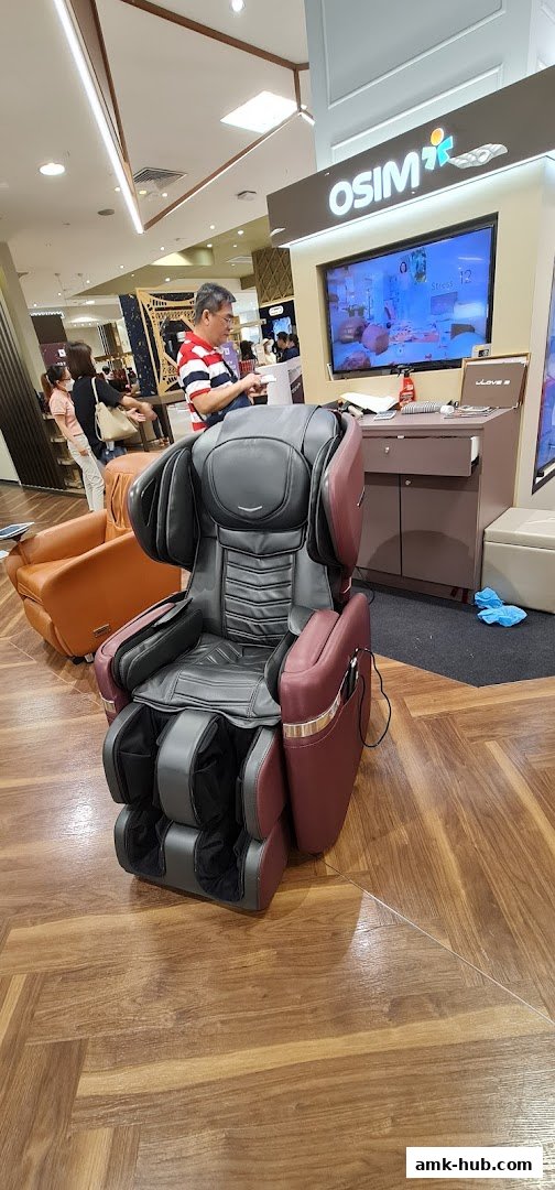 A person is looking at a massage chair in an OSIM store.