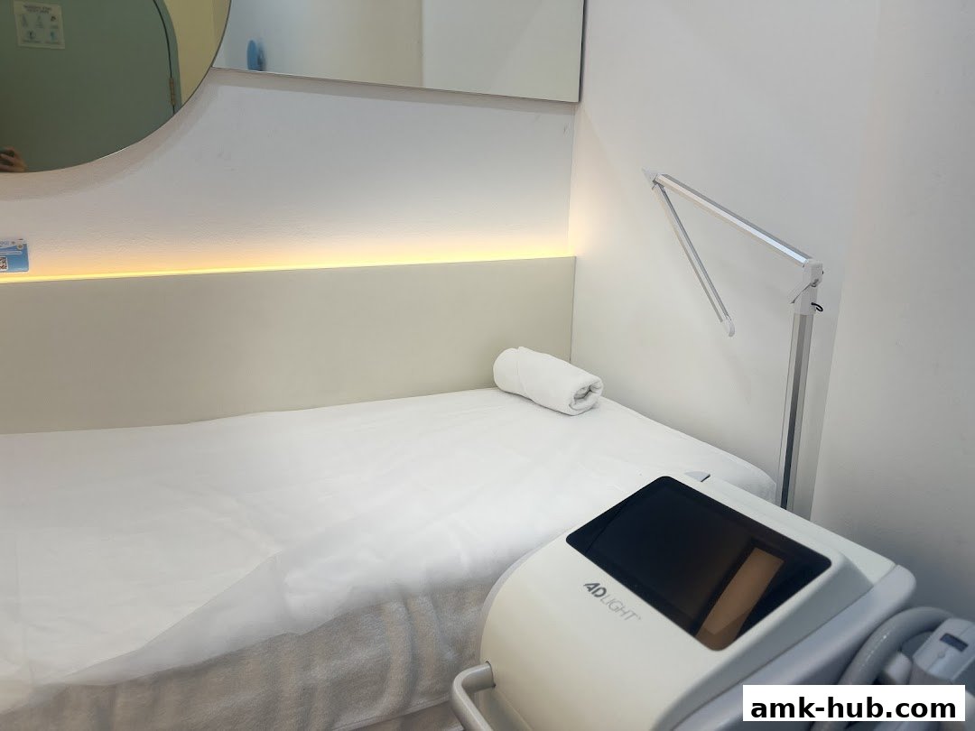A clean treatment room with a bed, lamp, and IPL machine.