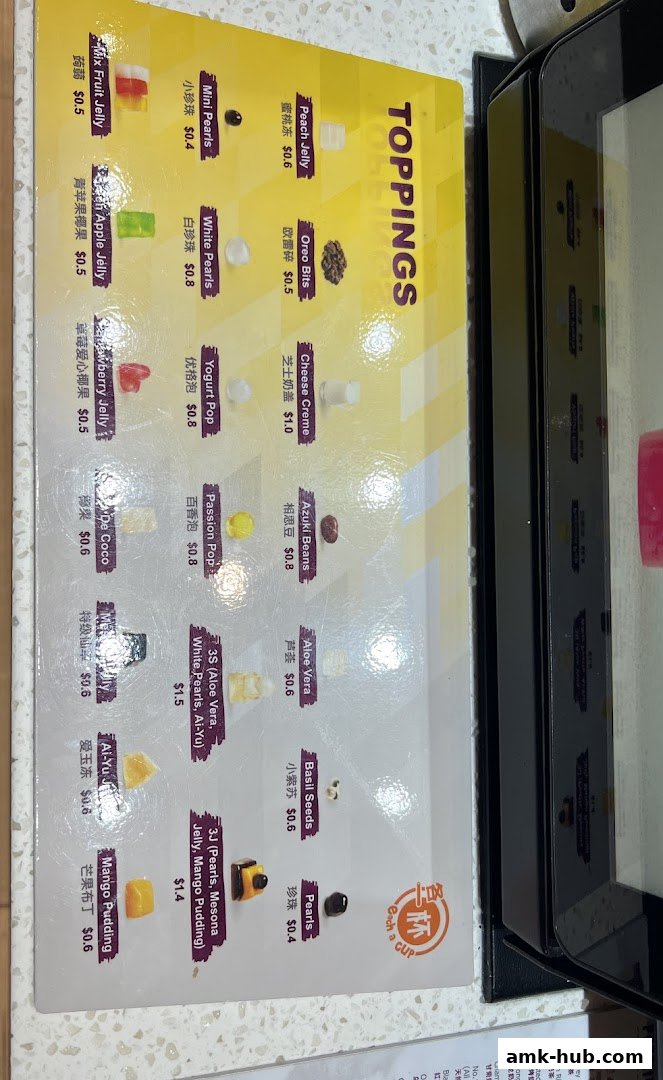 A menu board displaying various toppings for drinks with their prices.