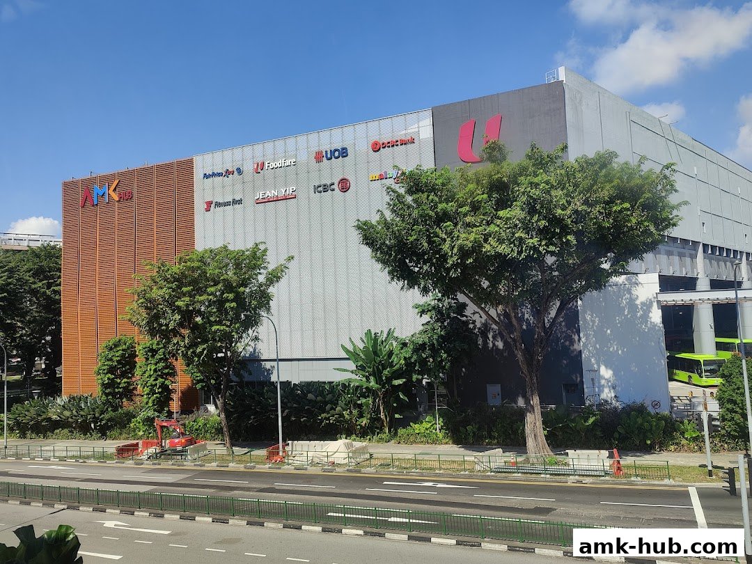 Exterior view of a modern building with various retail and service brand logos displayed.