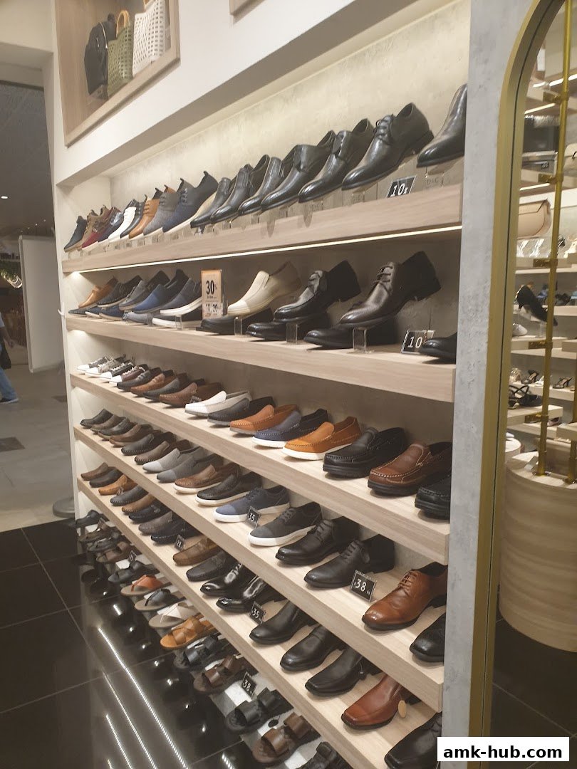 A wide selection of men's dress shoes and casual footwear displayed on shelves.
