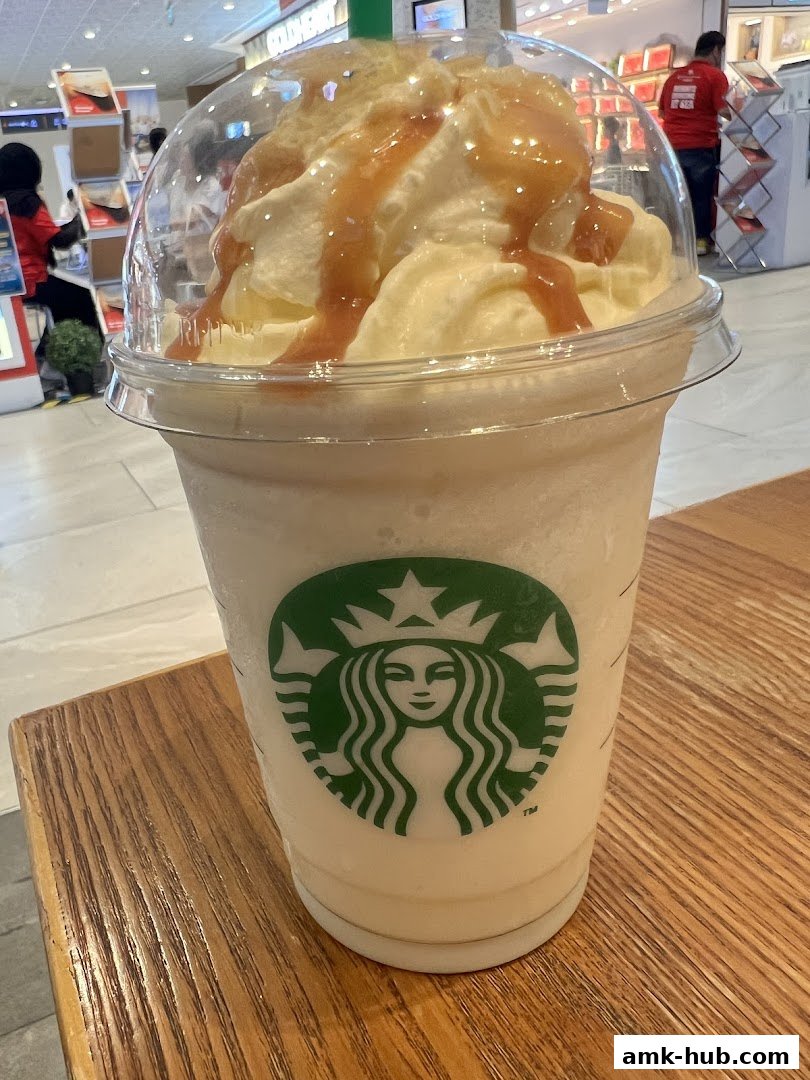 A close-up of a Starbucks Frappuccino with whipped cream and caramel drizzle.