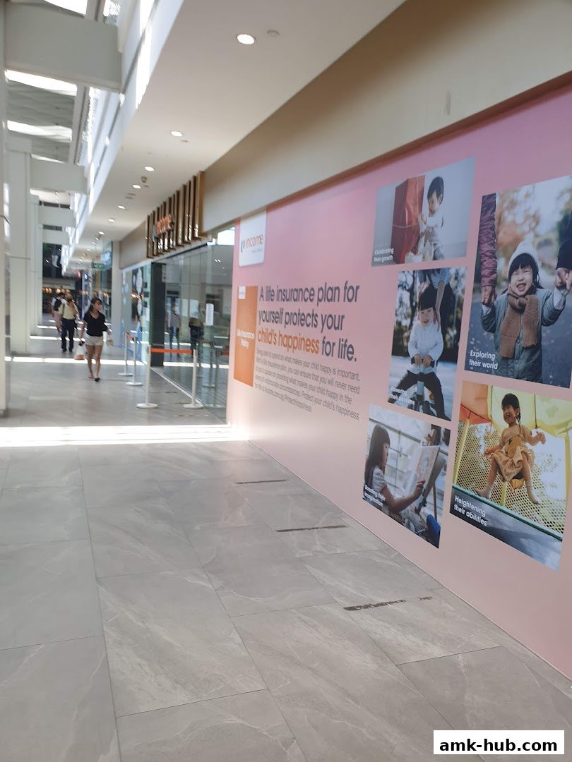 The Income Insurance Ang Mo Kio Branch storefront with a large pink advertisement.