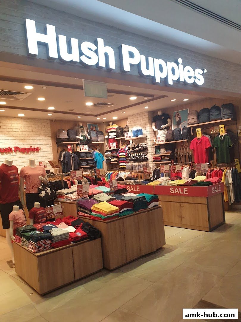 The Hush Puppies store displays a variety of colorful t-shirts and apparel on sale.