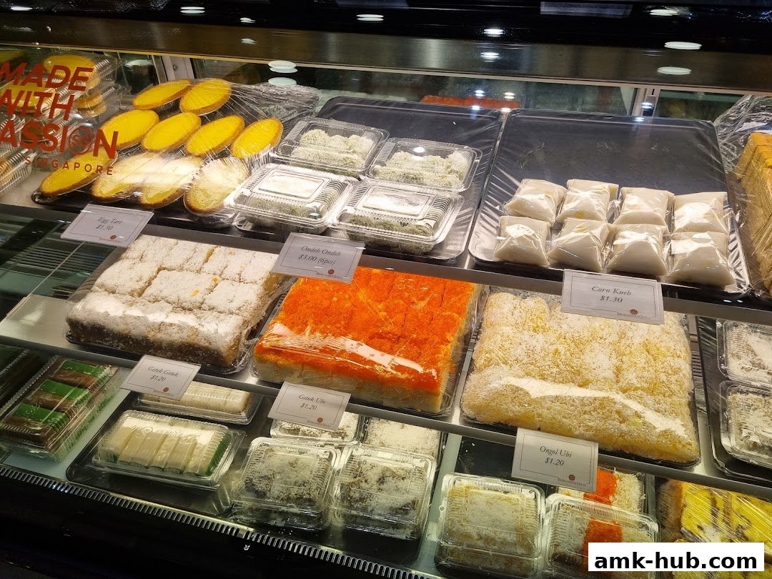 A display case filled with various sweet pastries and cakes, neatly packaged.