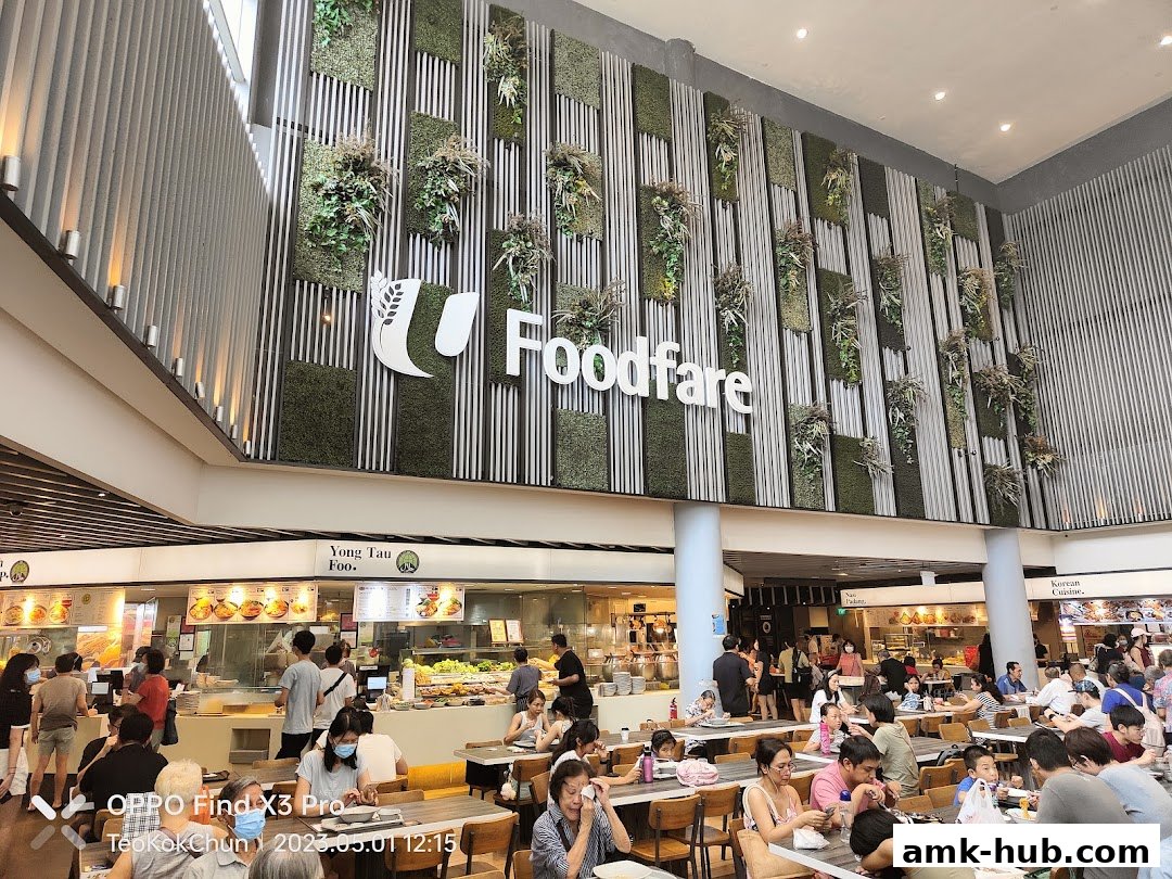 A bustling food court with diverse food stalls and many people dining.