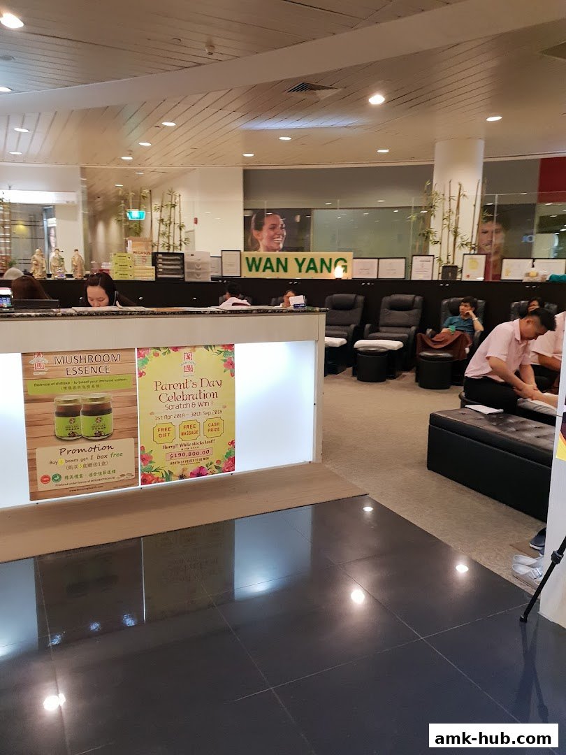 Interior of a health and foot reflexology center with massage chairs and promotional displays.