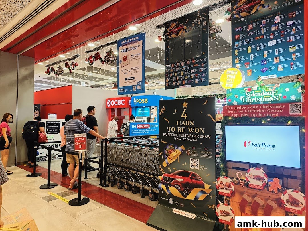 People queue at ATMs and a FairPrice supermarket entrance decorated for Christmas.