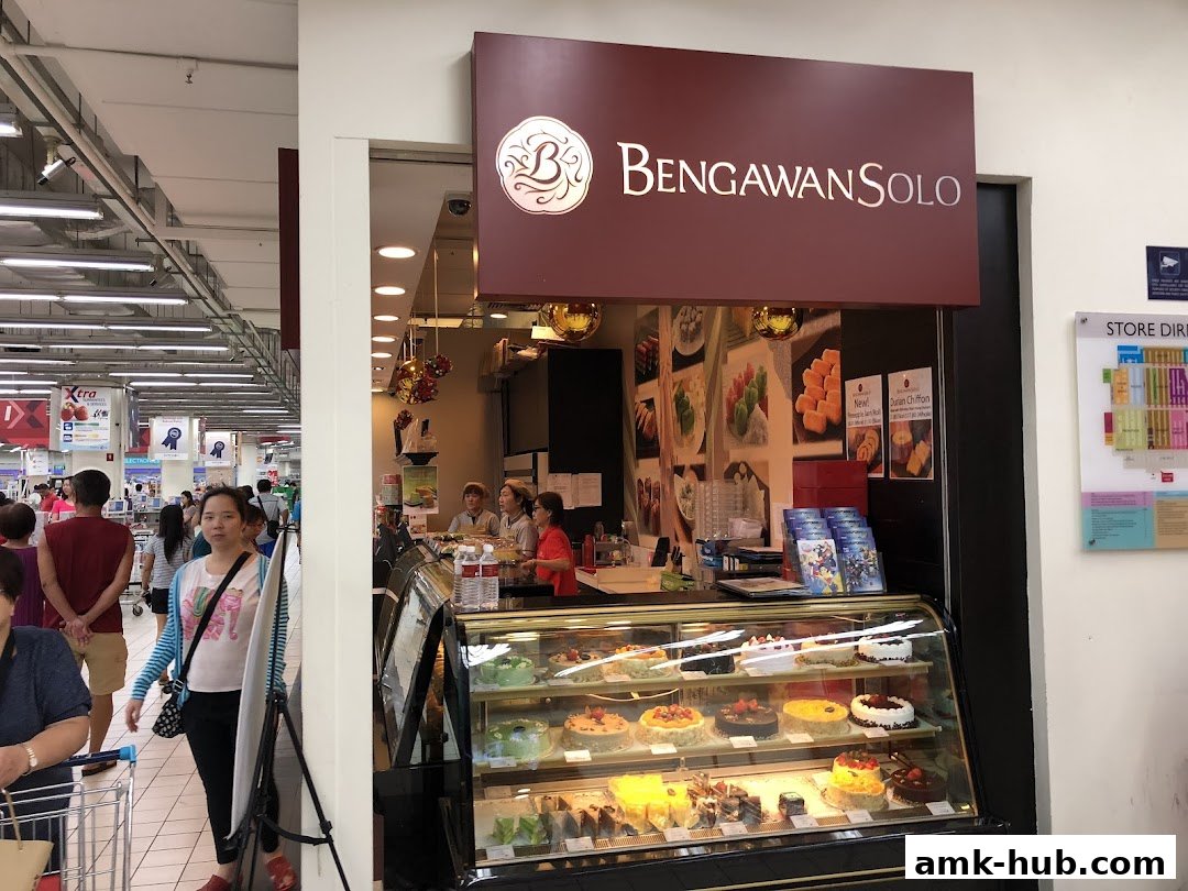 A Bengawan Solo shop with a display case full of cakes and pastries, and staff behind the counter.