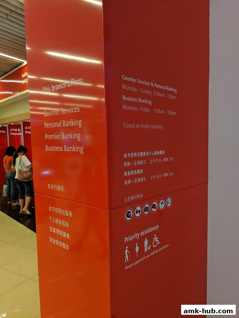 A red pillar displays banking services and operating hours for OCBC Bank Ang Mo Kio Central.