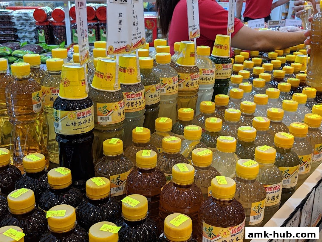 A display of various bottled tonic drinks with yellow caps and labels.