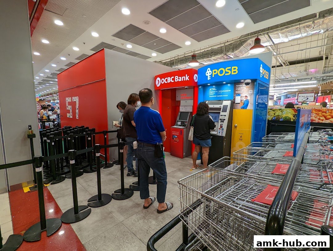 People queue at OCBC and POSB ATMs located inside a Fairprice Xtra supermarket.