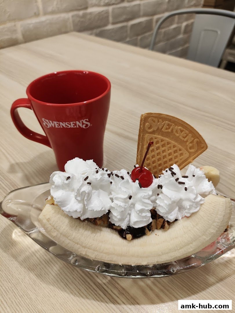 A Swensen's banana split with whipped cream, cherry, and a waffle cone.