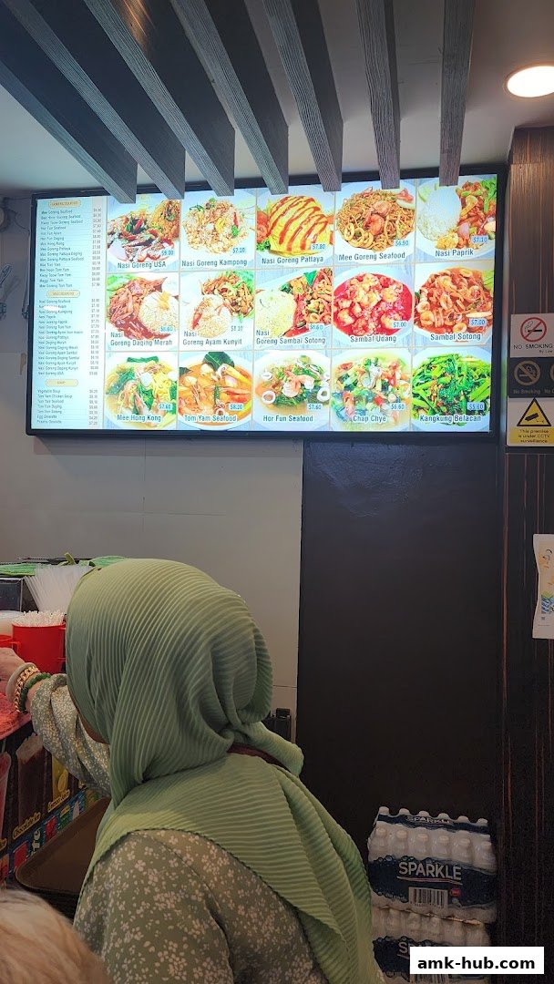 A digital menu board displays various Asian dishes with appetizing images and prices.