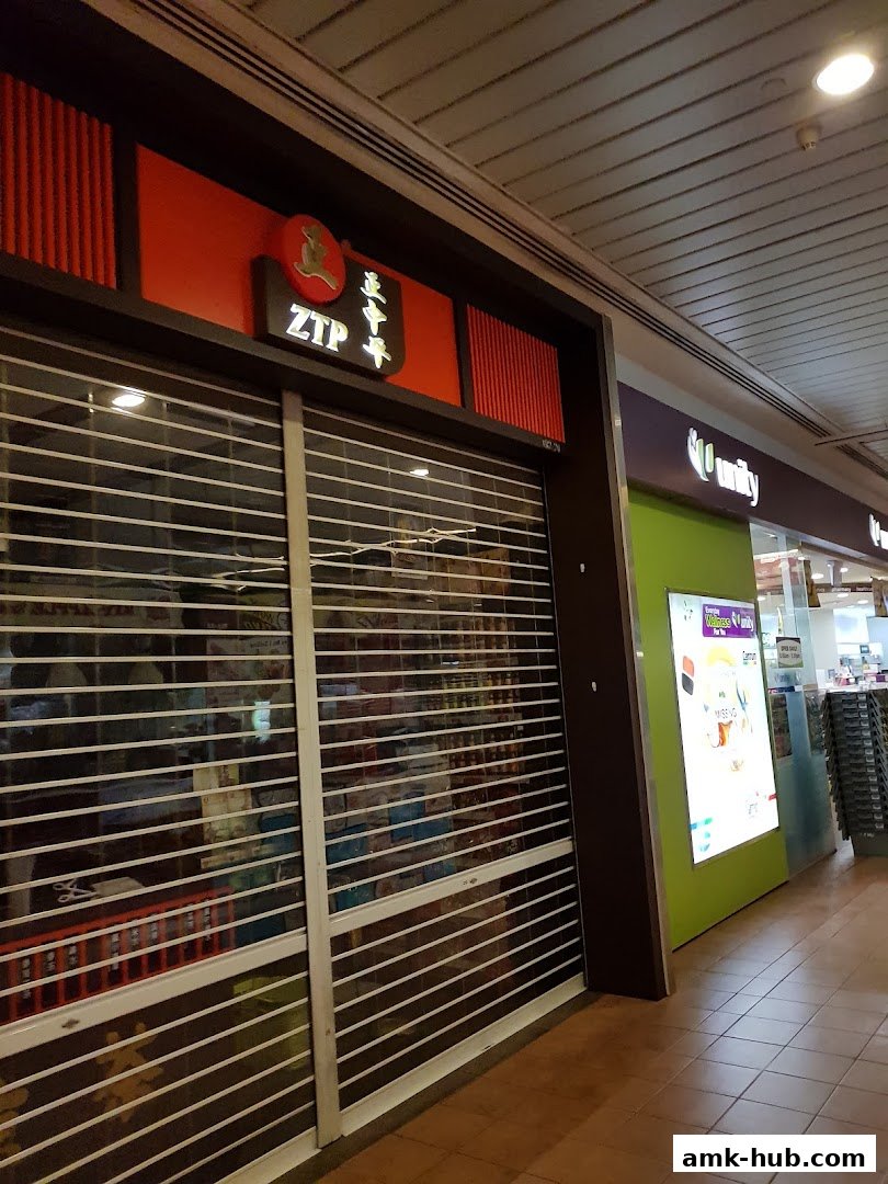 The closed storefront of ZTP, a shop with a red and dark brown facade and a prominent sign.