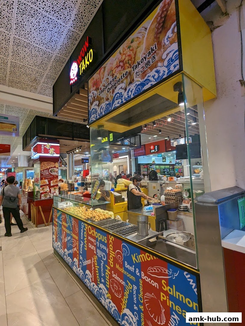 A vibrant food stall named Wow Tako, specializing in Japanese Takoyaki and Omelette.