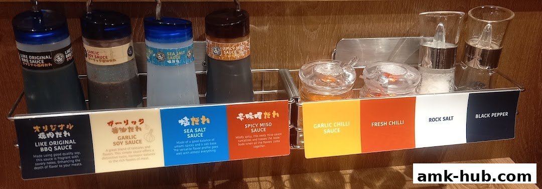 A selection of sauces and seasonings for yakiniku, including BBQ sauce, soy sauce, and chili.