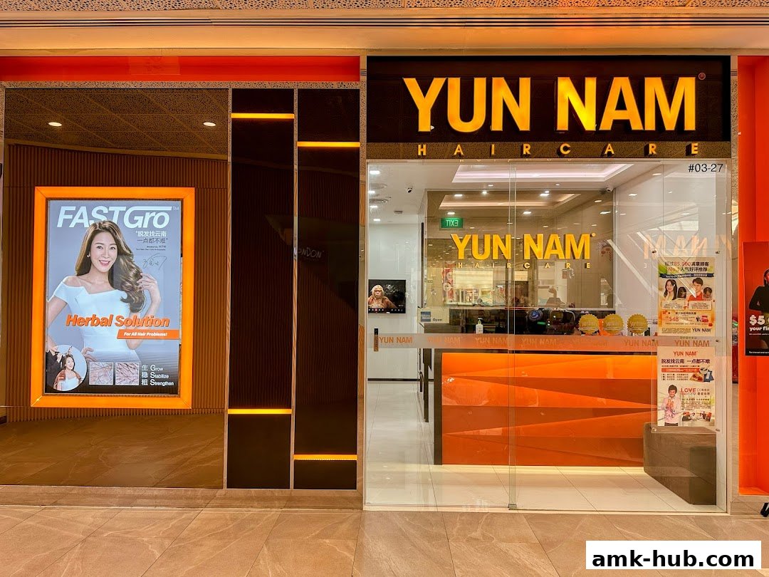 The storefront of Yun Nam Hair Care, featuring a bright orange reception desk and promotional posters.