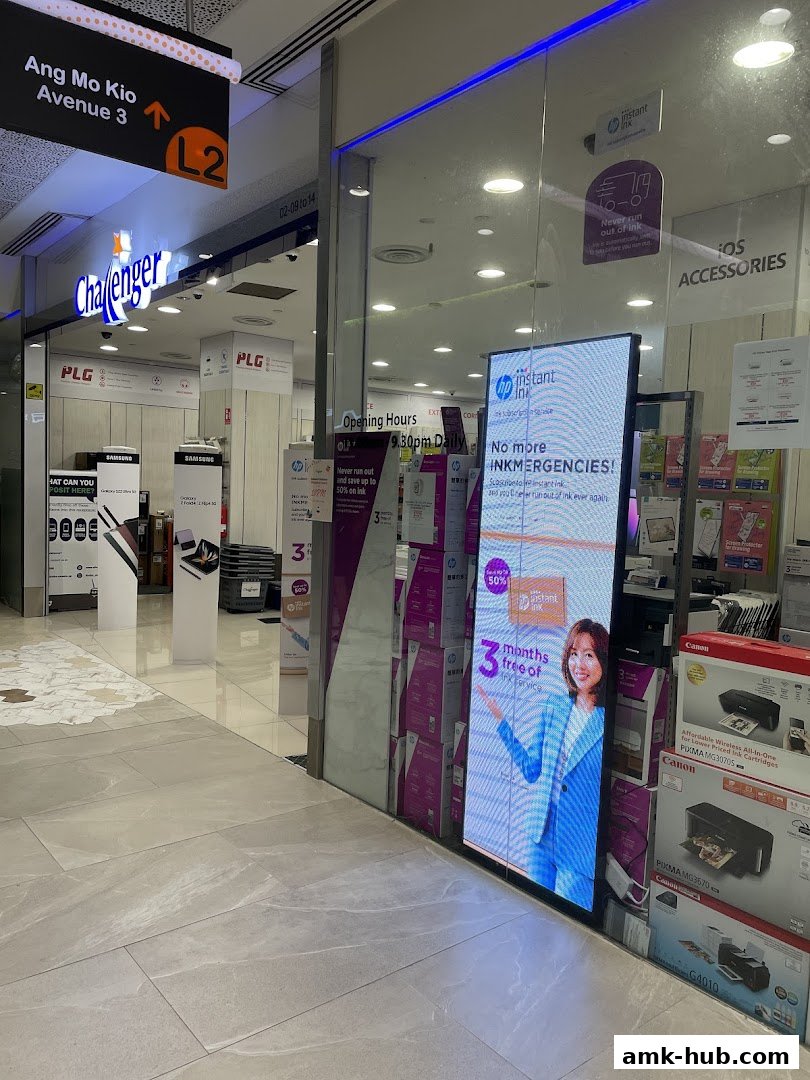 The exterior of a Challenger electronics store with a digital display advertising HP Instant Ink.