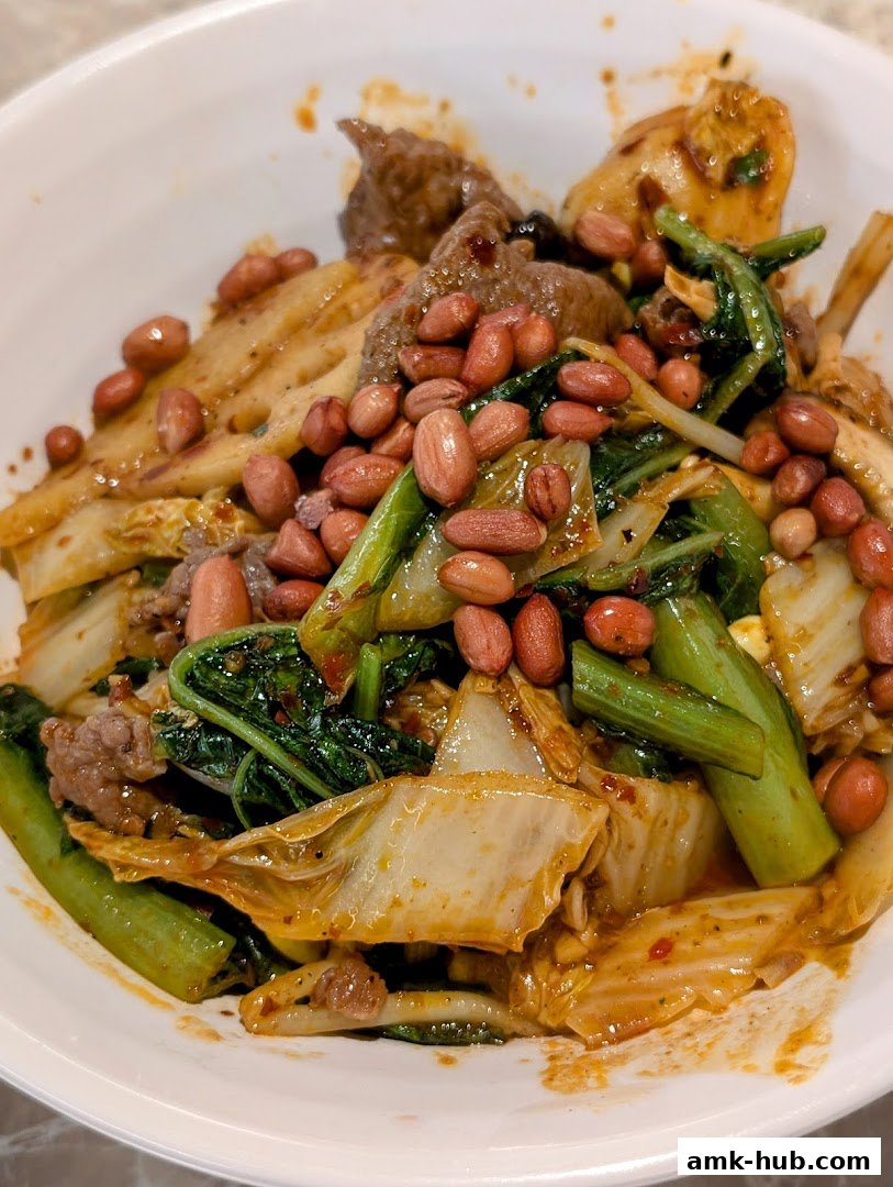 A close-up shot of a spicy fragrant pot filled with meat, vegetables, and peanuts.