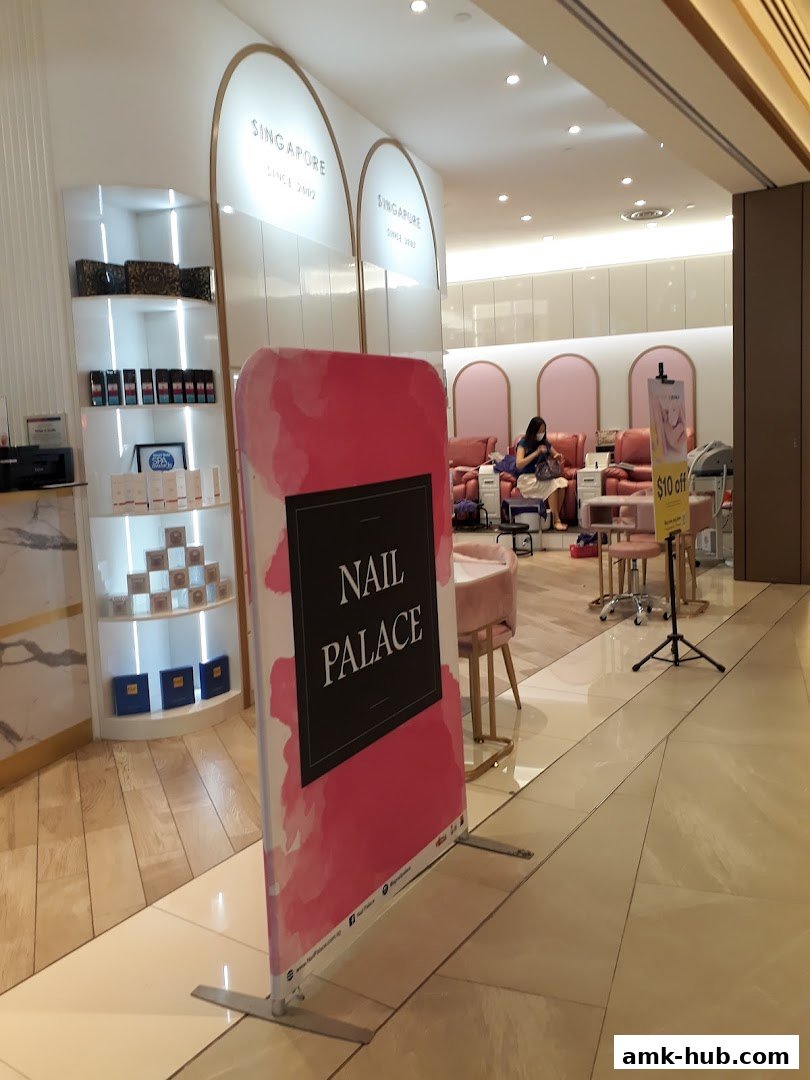 The Nail Palace shop interior with pink chairs and a sign advertising $10 off.