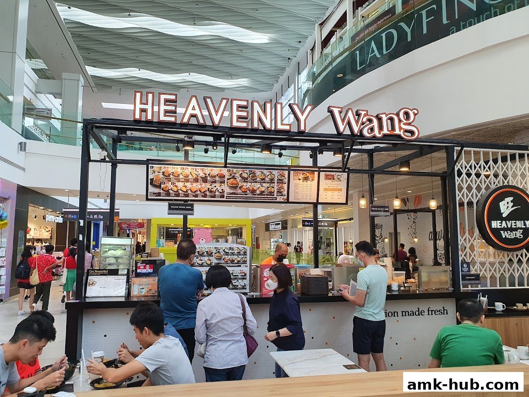 People ordering and eating at Heavenly Wang, a food stall in a shopping mall.