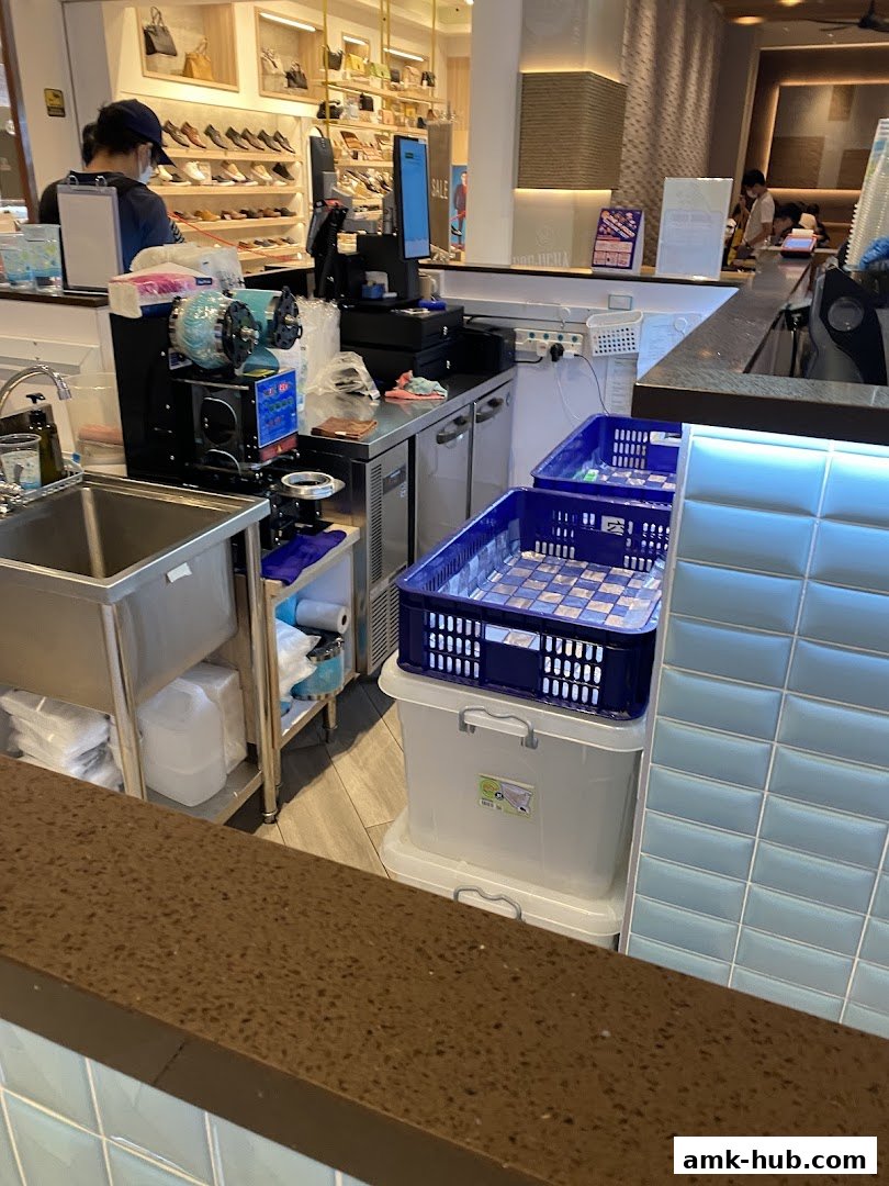 A view of a Mr. Coconut shop counter with equipment and storage containers.