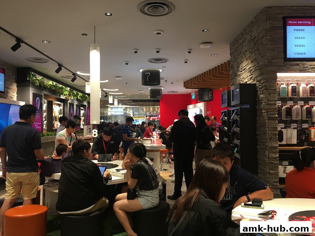 Interior of a busy Singtel shop with customers and staff interacting.