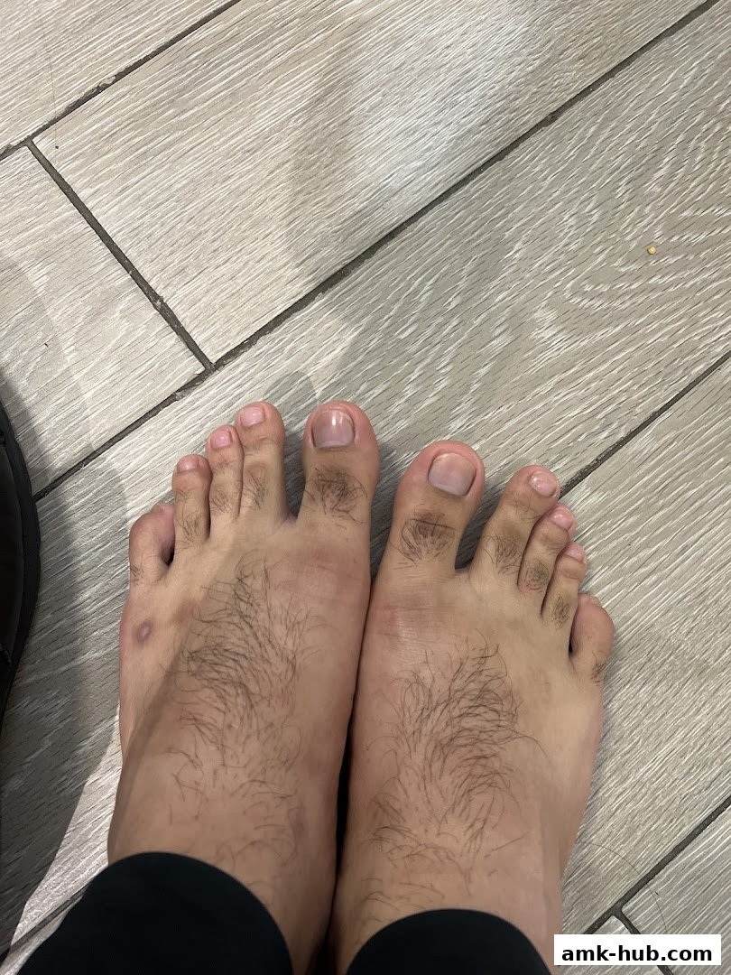 A close-up view of a person's feet with neatly trimmed toenails on a light-colored tiled floor.
