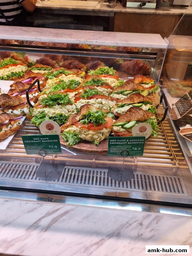 A display case filled with freshly made croissant sandwiches at Paris Baguette.