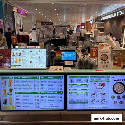 A brightly lit iTEA shop counter displaying various bubble tea and waffle menu items.
